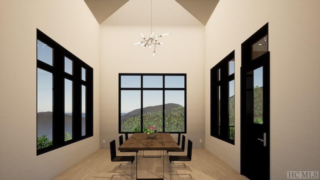 dining space with a chandelier, a mountain view, and light wood-type flooring