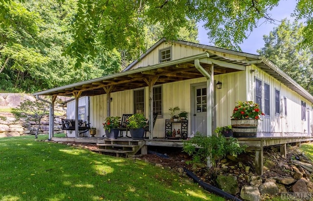 back of house featuring a porch and a yard