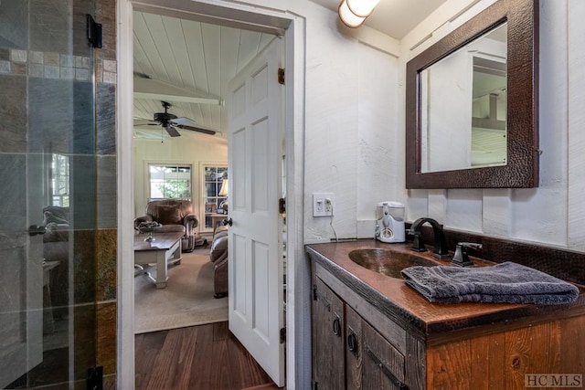 bathroom with hardwood / wood-style flooring, ceiling fan, vanity, vaulted ceiling, and a shower with shower door