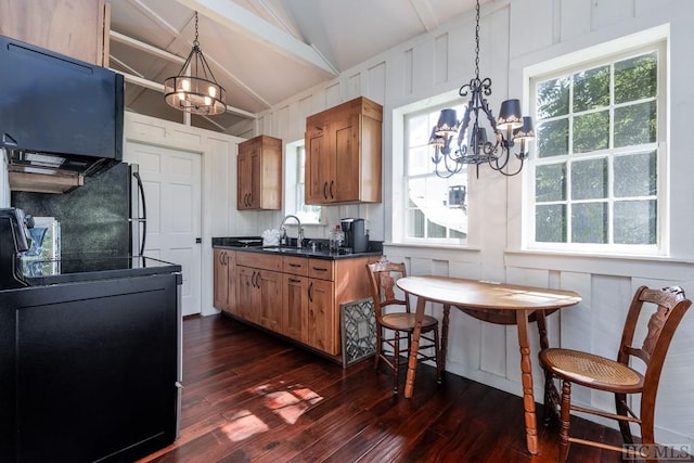 kitchen featuring lofted ceiling, electric range oven, dark hardwood / wood-style floors, and a chandelier