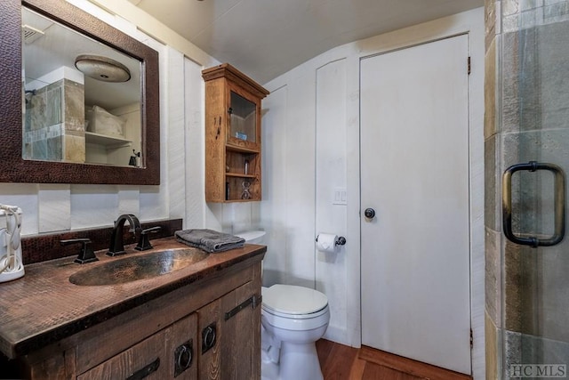 bathroom featuring walk in shower, vanity, toilet, and hardwood / wood-style flooring