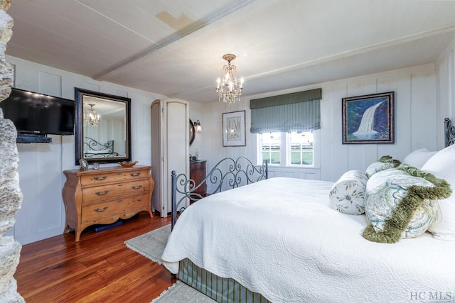 bedroom featuring dark hardwood / wood-style flooring and a chandelier