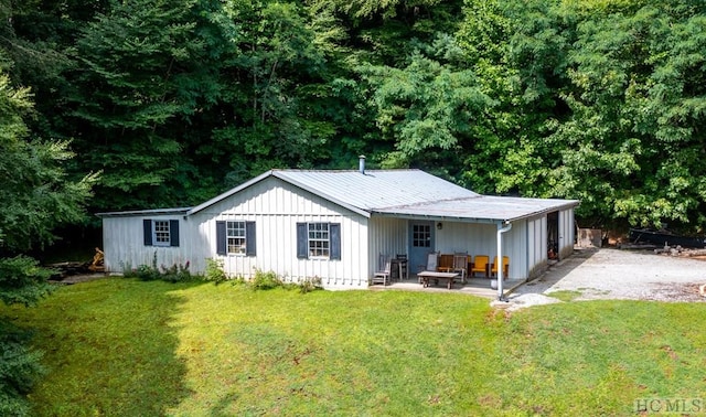 back of property with a patio area and a lawn