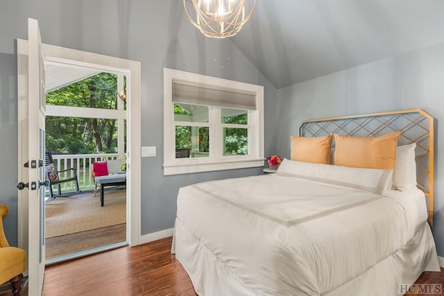 bedroom featuring dark hardwood / wood-style flooring, vaulted ceiling, and an inviting chandelier