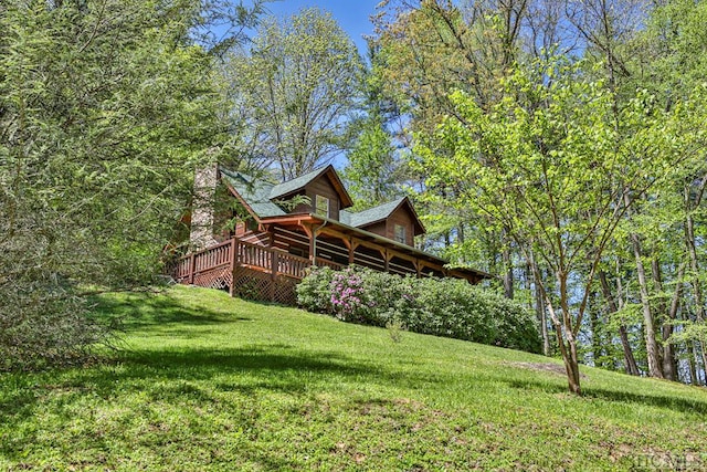 back of house featuring a lawn and a wooden deck