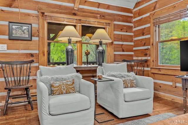 living area with hardwood / wood-style flooring and wood walls