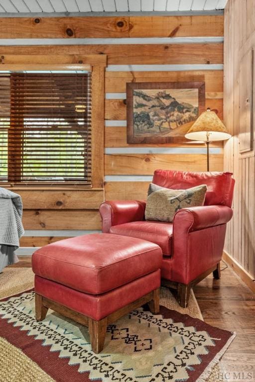 sitting room featuring hardwood / wood-style flooring, wooden ceiling, and wood walls