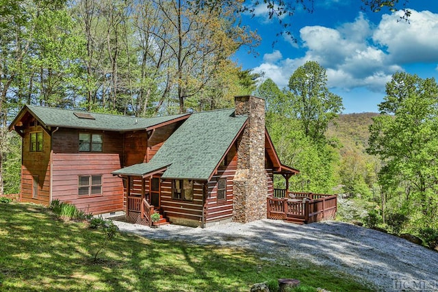 rear view of property with a deck and a yard