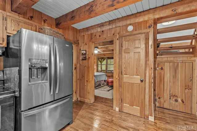 kitchen with beamed ceiling, wood walls, range, and stainless steel refrigerator with ice dispenser