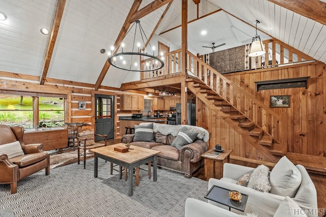 carpeted living room with wood walls, beamed ceiling, and high vaulted ceiling