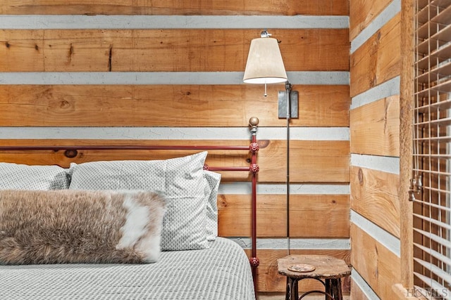 bedroom featuring wooden walls