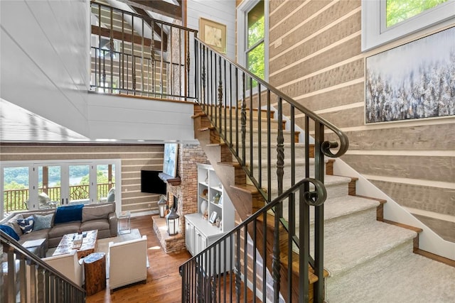 57 Loch Dr, Glenville, NC 28736 - staircase featuring wood finished floors, wooden walls, french doors, and a fireplace