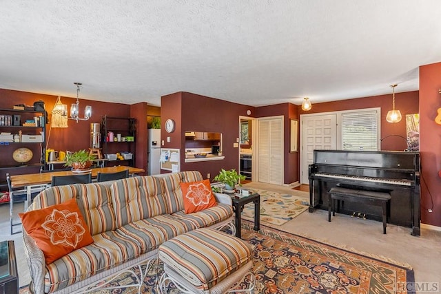 carpeted living room with a textured ceiling and a notable chandelier