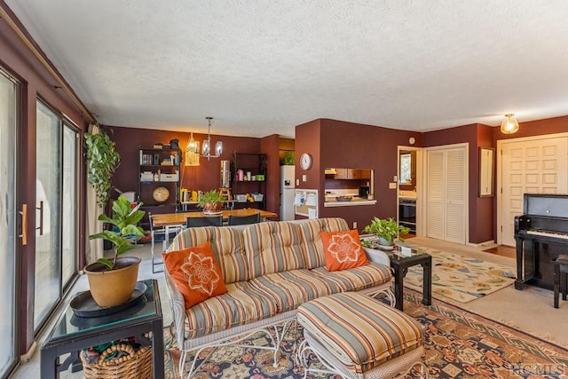 living room with a healthy amount of sunlight, an inviting chandelier, and a textured ceiling