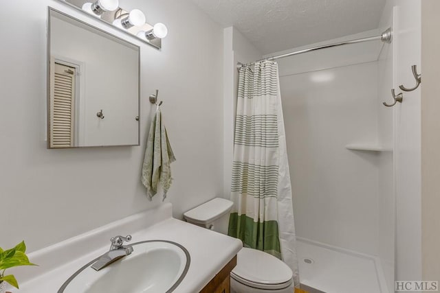 bathroom featuring vanity, a textured ceiling, toilet, and walk in shower