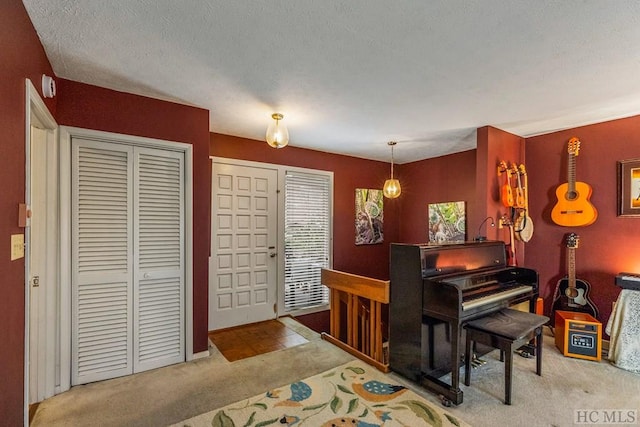 misc room with light carpet and a textured ceiling