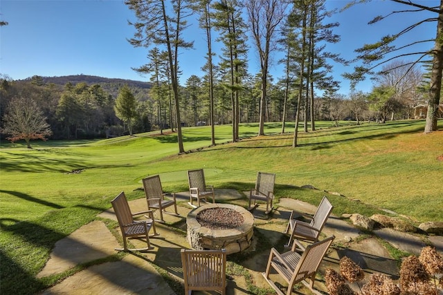 exterior space featuring a view of trees and a fire pit
