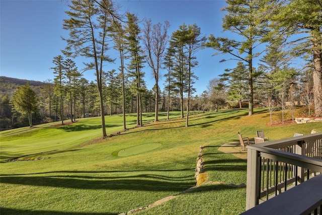surrounding community featuring a lawn and view of golf course