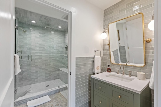 bathroom with vanity, tile walls, and a stall shower
