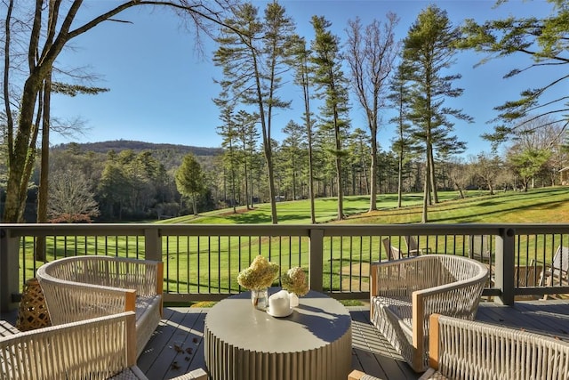 deck featuring view of golf course and a yard