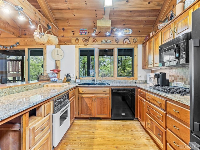 kitchen featuring wood ceiling, backsplash, lofted ceiling, light stone counters, and black appliances