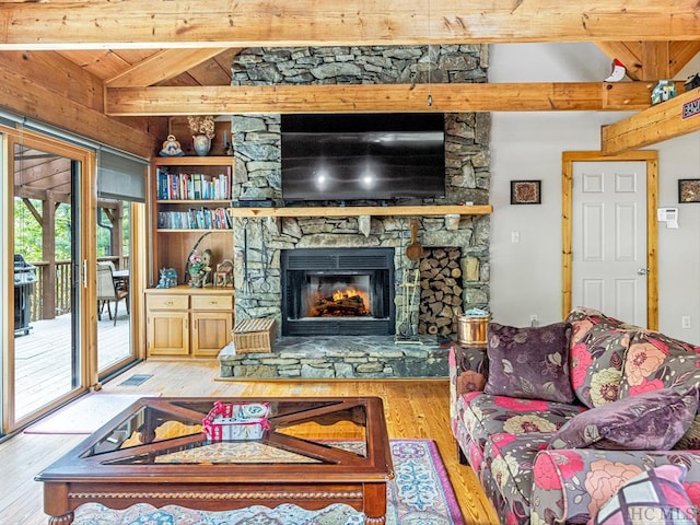 living room featuring vaulted ceiling with beams, a fireplace, and light hardwood / wood-style floors