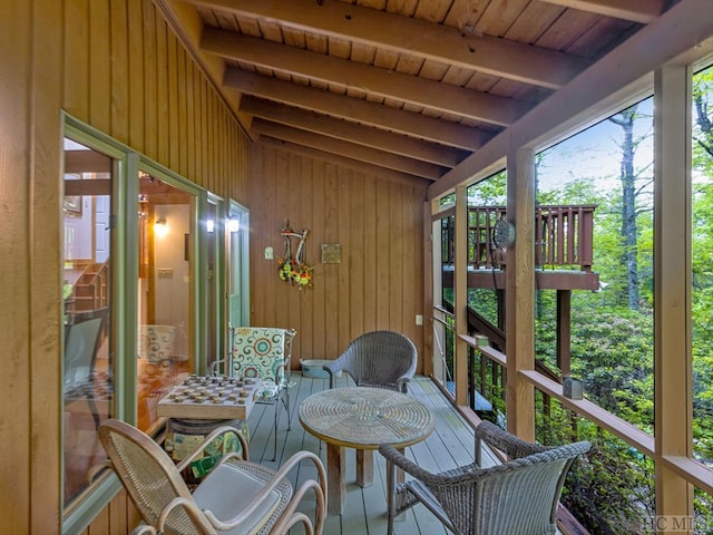 sunroom featuring wooden ceiling and lofted ceiling with beams