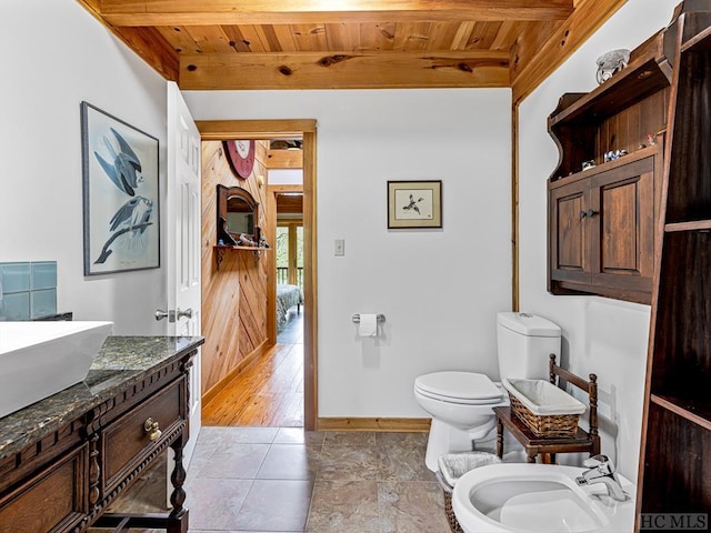 bathroom featuring toilet, vanity, a bidet, and wooden ceiling