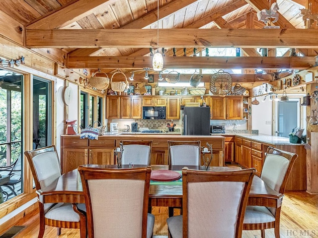 dining room with lofted ceiling with beams, wood ceiling, and light wood-type flooring