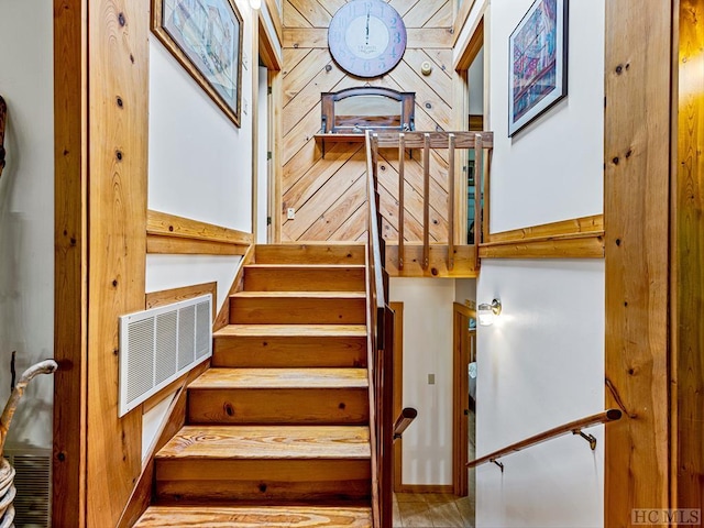 stairs featuring wood walls