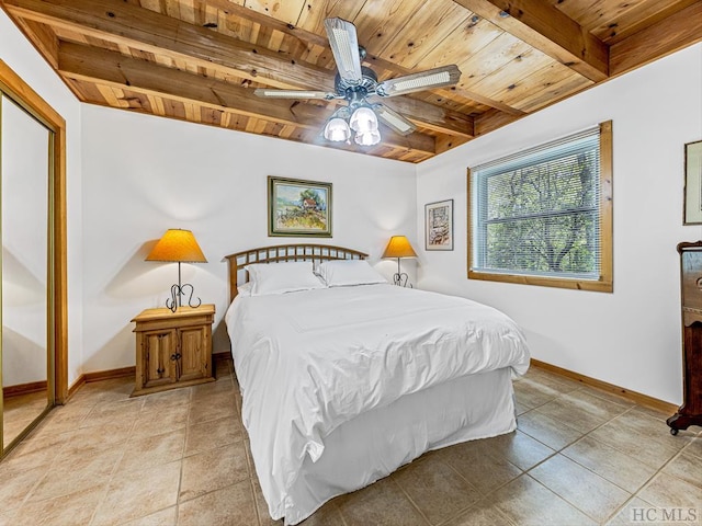 bedroom featuring ceiling fan, wooden ceiling, light tile patterned floors, and beam ceiling