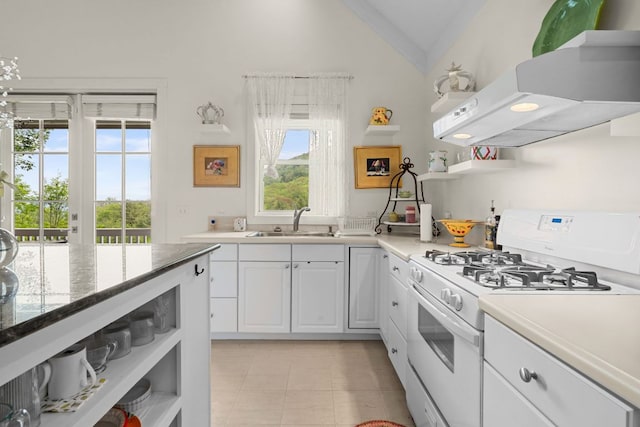 592 Whiteside Mountain Rd, Highlands, NC 28741 - kitchen featuring white gas range oven, open shelves, extractor fan, vaulted ceiling, and white cabinetry
