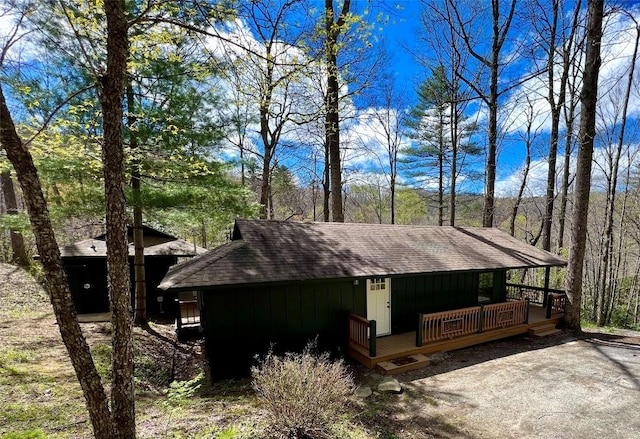 view of side of property featuring roof with shingles