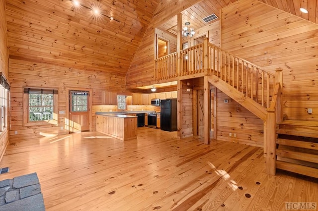 unfurnished living room with wood ceiling, light hardwood / wood-style floors, high vaulted ceiling, and wood walls