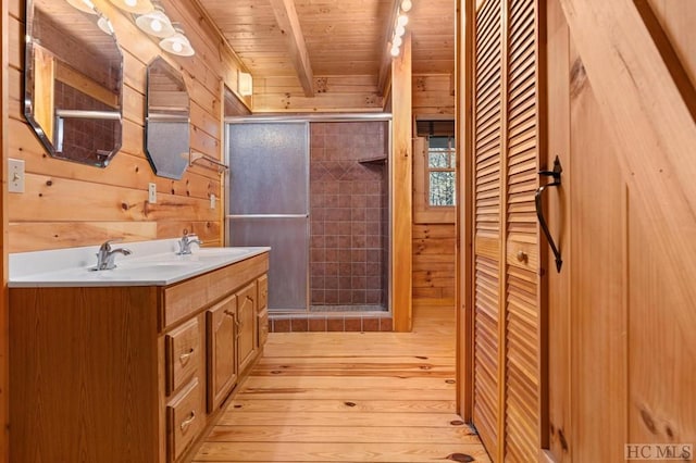 bathroom with beam ceiling, vanity, wood-type flooring, wooden ceiling, and wood walls