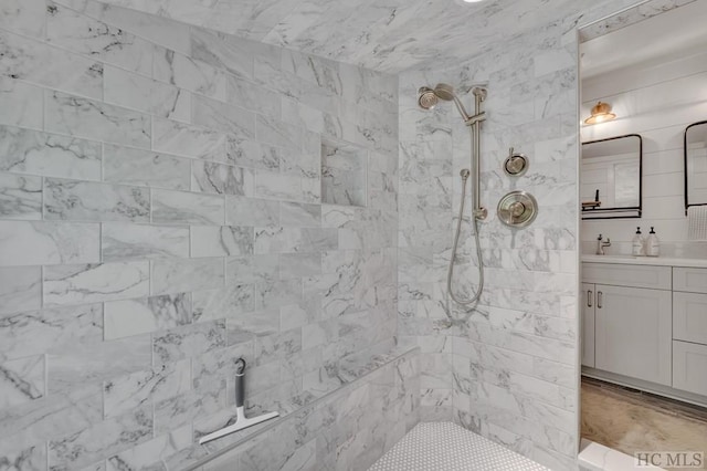 bathroom featuring a tile shower and vanity