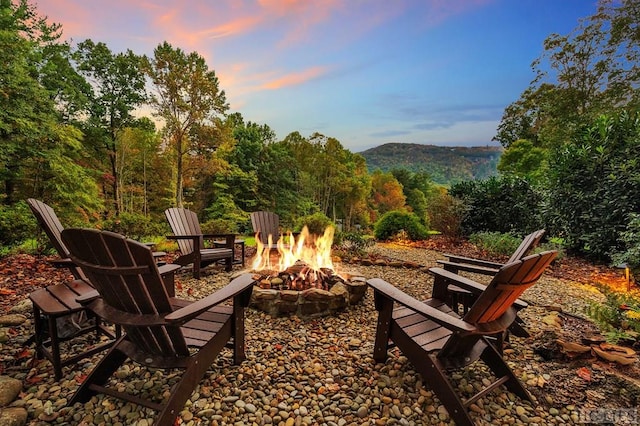 patio terrace at dusk with an outdoor fire pit and a mountain view