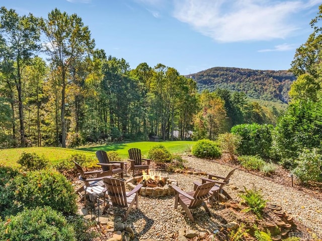 view of yard with a mountain view and an outdoor fire pit