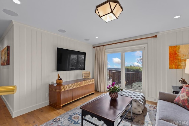 living room with ornamental molding and light hardwood / wood-style floors