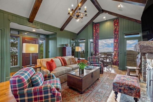 living room featuring hardwood / wood-style floors, a wealth of natural light, a notable chandelier, and beam ceiling