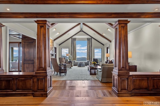 interior space with lofted ceiling with beams, crown molding, and decorative columns