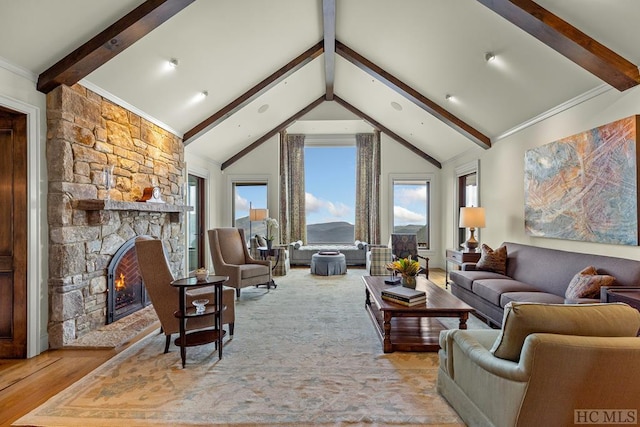 living room featuring light hardwood / wood-style flooring, a stone fireplace, plenty of natural light, and beamed ceiling