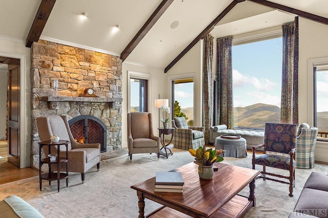 living room with a mountain view, a stone fireplace, high vaulted ceiling, and beamed ceiling