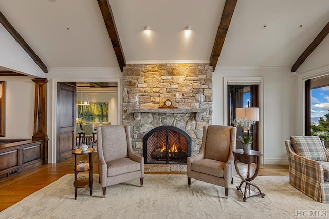 sitting room with a fireplace, light hardwood / wood-style floors, and lofted ceiling with beams