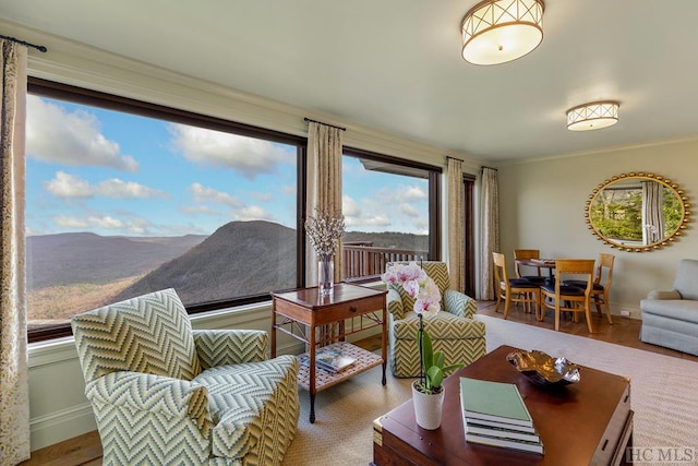 living room featuring crown molding, plenty of natural light, and a mountain view