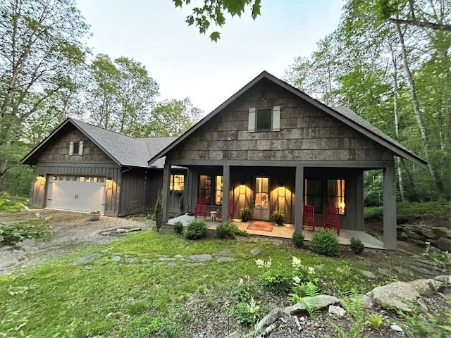 11 Feldspar Ln, Sapphire, NC 28774 - view of front facade featuring a porch, board and batten siding, dirt driveway, and a garage