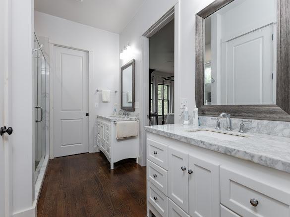 11 Feldspar Ln, Sapphire, NC 28774 - bathroom with a shower stall, two vanities, and wood finished floors