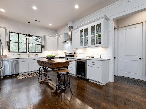 11 Feldspar Ln, Sapphire, NC 28774 - kitchen with stainless steel dishwasher, wall chimney range hood, wine cooler, white cabinetry, and light countertops