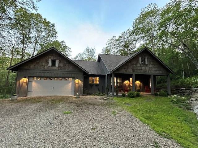 11 Feldspar Ln, Sapphire, NC 28774 - view of front facade featuring driveway, an attached garage, board and batten siding, and a porch