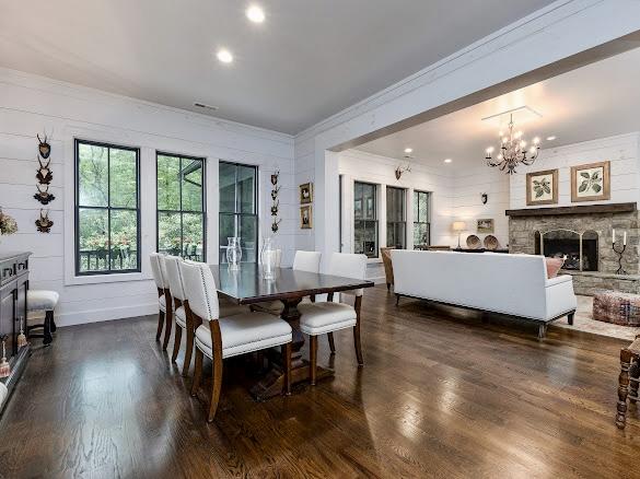 11 Feldspar Ln, Sapphire, NC 28774 - dining space with ornamental molding, a chandelier, dark wood finished floors, a stone fireplace, and recessed lighting